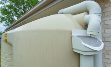 White rain water tanks and pump - Chris Vella Plumbing & Gasfitting